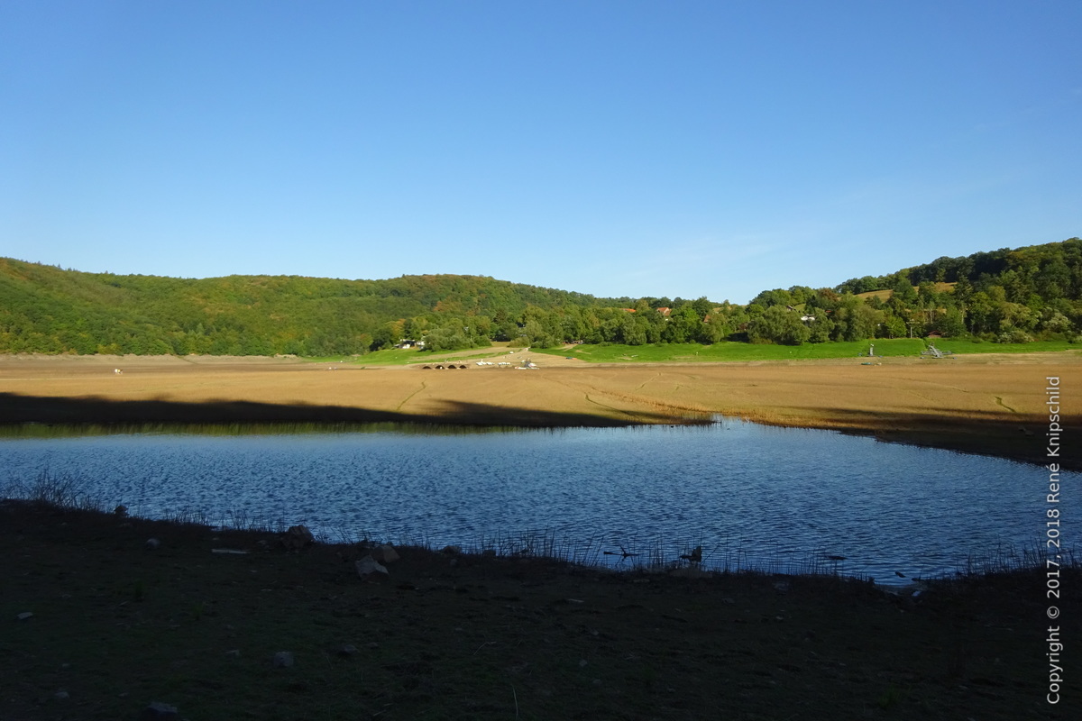 Pfütze in der Größe eines Teichs im ausgetrockneten Ederfeld mit schönem Himmel-Erde-Wasser-Kontrast