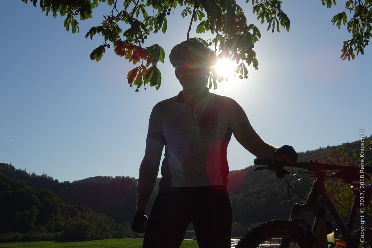 Silhouette vor Sonne: rk neben Bike